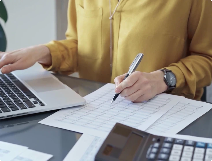 Calculating numbers with laptop and pen