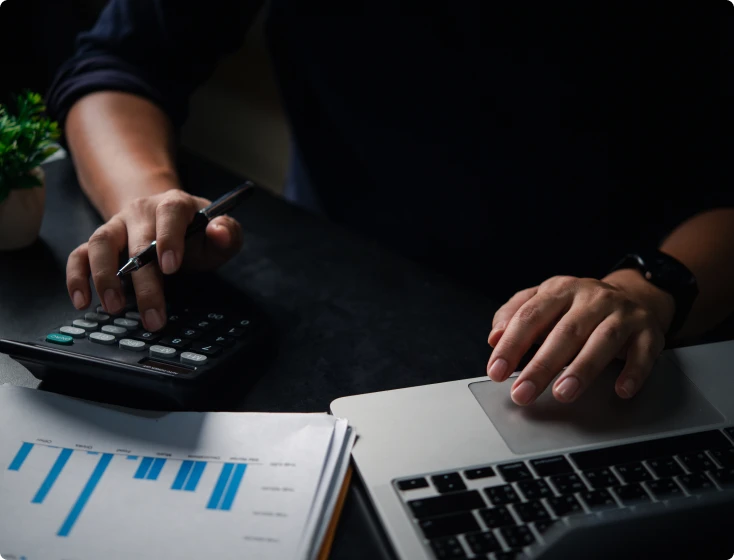 Person using calculator and laptop
