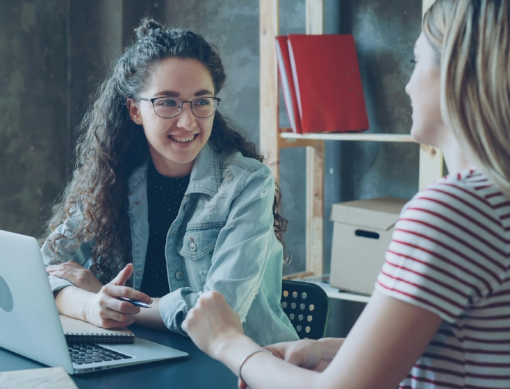 Two women having a friendly meeting in a cozy office.
